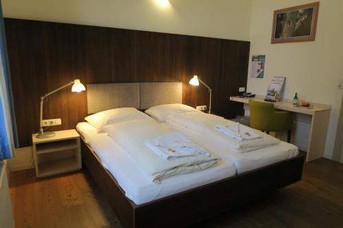 a bedroom with a large bed with towels on it at Villa Sonnwend National Park Lodge in Rossleithen