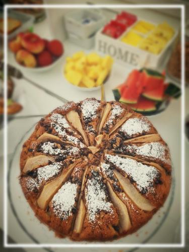 a cake with powdered sugar on a table with other desserts at Donna Maria b&b in Favignana