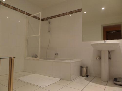 y baño con bañera, lavamanos y ducha. en Hôtel Restaurant Erckmann Chatrian, en Phalsbourg