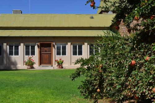 a house with an orange tree in front of it at Savanna Guest Farm in Grünau