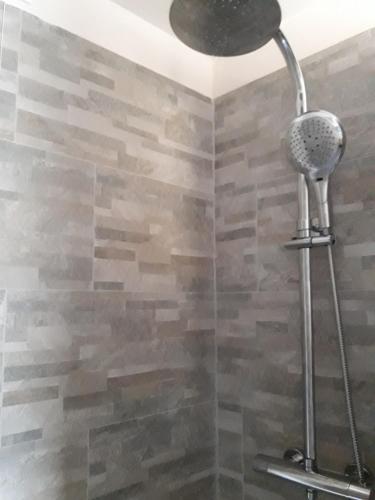 a shower in a bathroom with a stone wall at Kikka's House in La Spezia