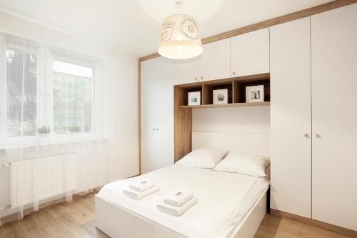a white bedroom with a white bed and a window at Sea Point Apartment - Hav Aparts in Gdańsk