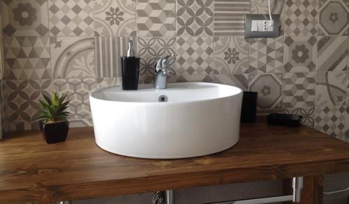 a white sink on a wooden counter in a bathroom at Alloggio Lentini in Carlentini