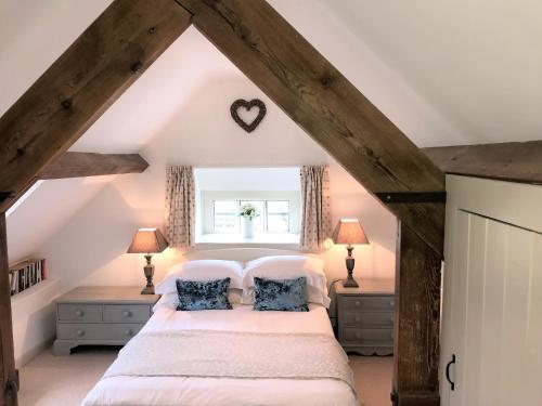 a bedroom with a large bed in a attic at Cornerstone Cottage in Chipping Campden