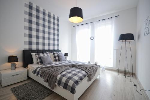 a bedroom with a bed with a checkered wall at Apartament nad Drwęcą I in Ostróda