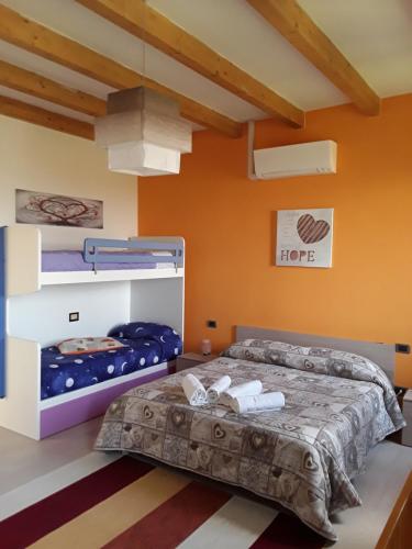 a bedroom with a bed and two bunk beds at Mu & Mu in Borgoforte