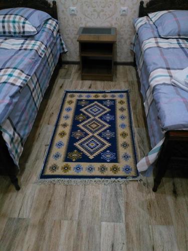 a room with two beds and a rug on the floor at Apartments on Akhalubani St 2 in Tbilisi City
