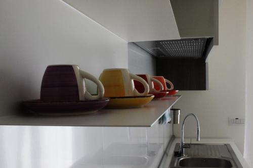 a kitchen with bowls and plates on a counter at Alloggio Lentini in Carlentini