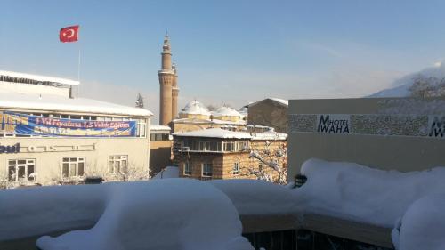 a view of a snowy city with a mosque in the background at Waha Hotel in Bursa