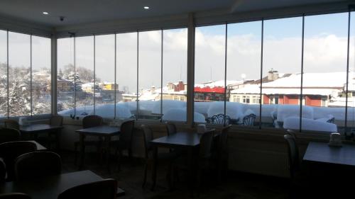 a restaurant with tables and chairs and a large window at Waha Hotel in Bursa