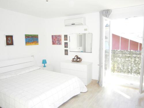 a white bedroom with a white bed and a window at La Finestra sul Cielo in San Benedetto del Tronto