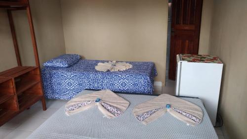 two pairs of shoes sitting on a bed in a room at Pousada Vila Alter in Alter do Chao