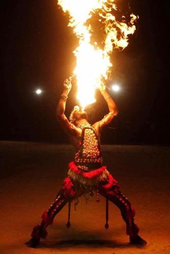 a woman is holding up a fire in the air at The Gunjur Project Lodge in Gunjur