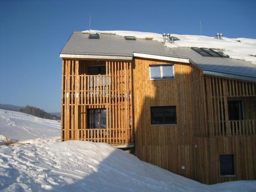 a wooden building in the snow with snow around it at Apartmán u Kamila in Dolní Morava