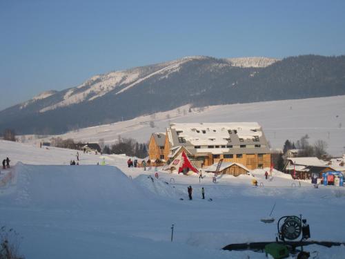a group of people skiing in the snow near a ski lodge at Apartmán u Kamila in Dolní Morava