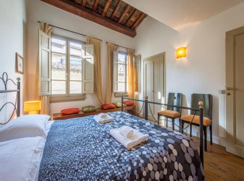 a bedroom with a bed with a blue and white blanket at Mamo Florence - Uffizi Gallery Rooftop Apartment in Florence
