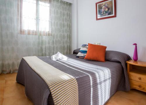 a bedroom with a bed with a striped blanket at Complejo Bellavista Residencial in Pego