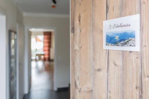 a sign hanging on a wooden wall in a room at HOMEBOUND APARTMENTS Salzburg City II - contactless check-in in Salzburg