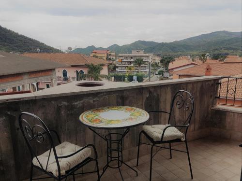 a table and chairs on a balcony with a view at La Porta dell'Alcantara in Gaggi