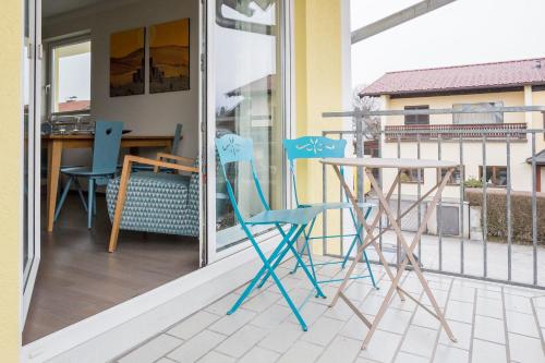 a pair of chairs and a table on a balcony at HOMEBOUND APARTMENTS Salzburg City II - contactless check-in in Salzburg