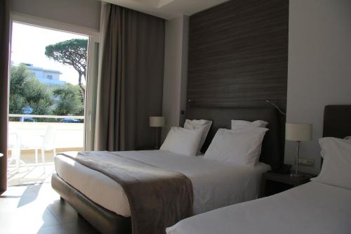 a hotel room with two beds and a large window at Hotel Marad in Torre del Greco