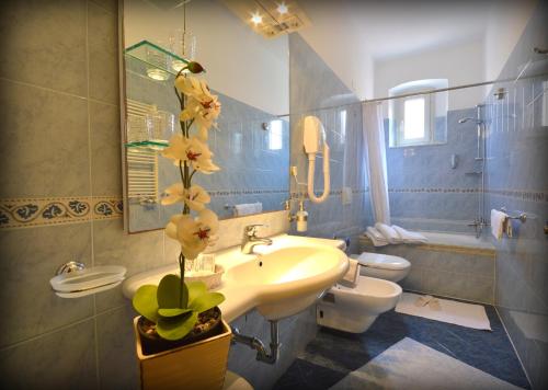 a bathroom with a sink and a toilet and a sink at Hotel Genova in La Spezia