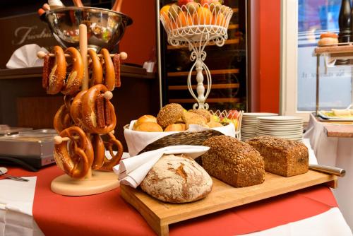 a table topped with bread and pretzels and other foods at Altstadthotel Am Theater in Cottbus