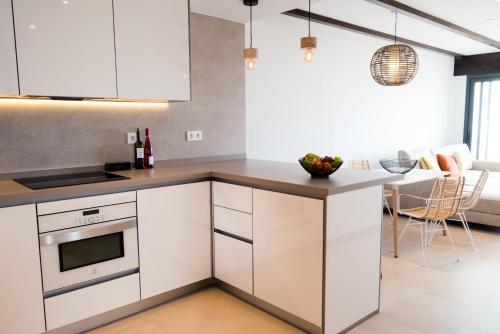 a kitchen with white cabinets and a counter top at Complejo Bellavista Residencial in Pego