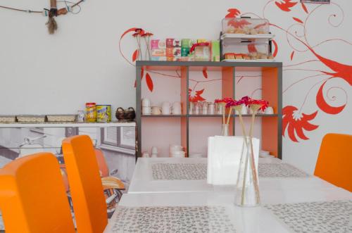 a dining room with a table and orange chairs at Hostal Los Calatravos in Alcañiz