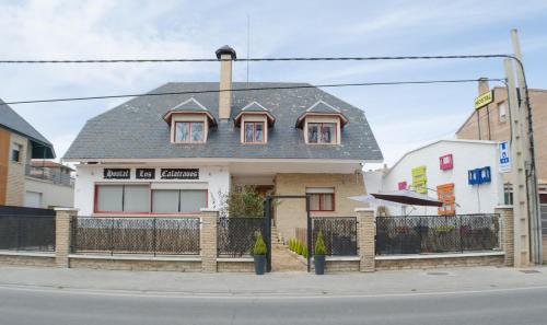 a woman standing in front of a house at Hostal Los Calatravos in Alcañiz