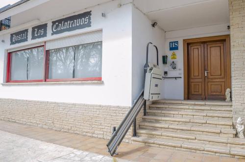 a building with a door and stairs in front of it at Hostal Los Calatravos in Alcañiz