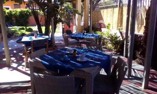 a table with chairs and a table cloth at Hotel I Colori in SantʼAntìoco