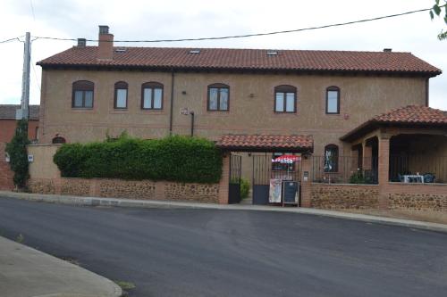 a large brick house on the side of a street at Hotel Rural Casa El Cura in Calzadilla de los Hermanillos
