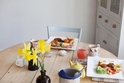 a wooden table with two plates of food on it at Ye Olde Saddlery B&B in Neatishead