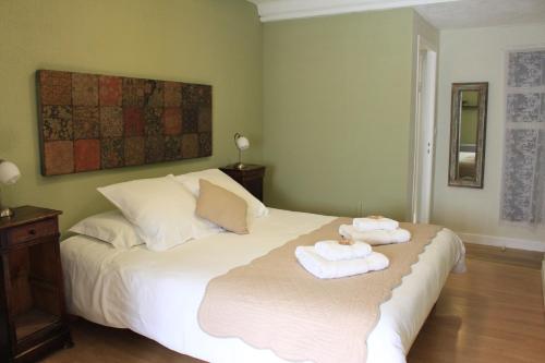 a bedroom with a white bed with towels on it at L'Auberge De Montpezat in Montpezat-sous-Bauzon