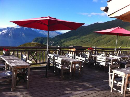 a deck with tables and umbrellas on a mountain at Hamilton Lodge & Spa in Belalp
