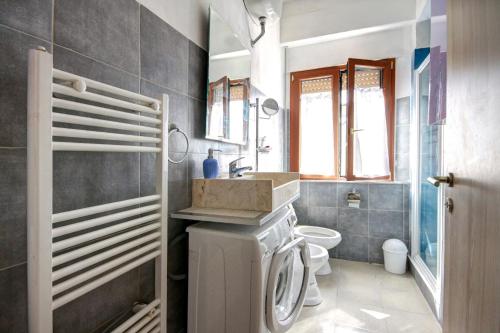 y baño con lavabo y lavadora. en Maison Bury en Rapolano Terme