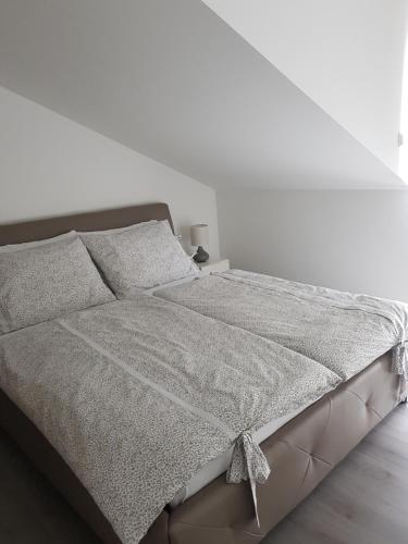 Cama en habitación blanca con pared blanca en Ivana, en Trogir