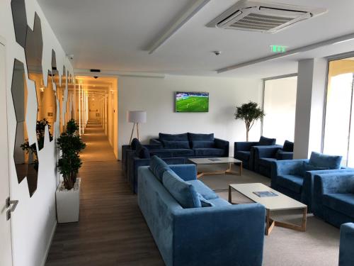 a living room with blue couches and a tv at Hotel do Parque in Viana do Castelo