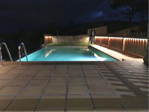 a man standing in a swimming pool at night at Can Sabate in Hospitalet de l'Infant