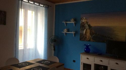 a bedroom with a blue wall with a window and a table at Casa LA MARINA in Manarola