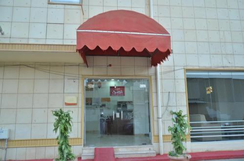 a store front with a red awning over the door at شقق منازل القصواء للشقق المخدومة إقتصادي in Buraydah