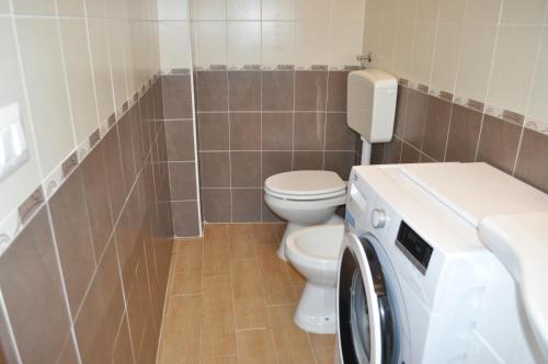 a bathroom with a toilet and a washing machine at Villa Dei Tigrotti in Santa Maria di Castellabate