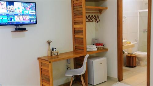 a room with a computer desk and a television on a wall at Pousada Jeri Dunas in Jericoacoara