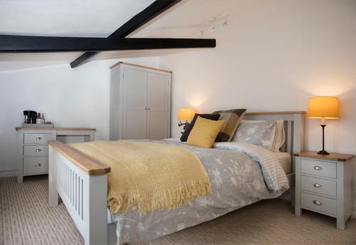 um quarto com uma cama com duas mesas de cabeceira e dois candeeiros em Ye Olde Saddlery B&B em Neatishead