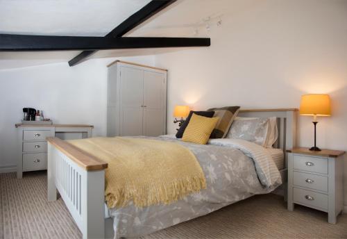 a bedroom with a bed with two night stands and two lamps at Ye Olde Saddlery B&B in Neatishead