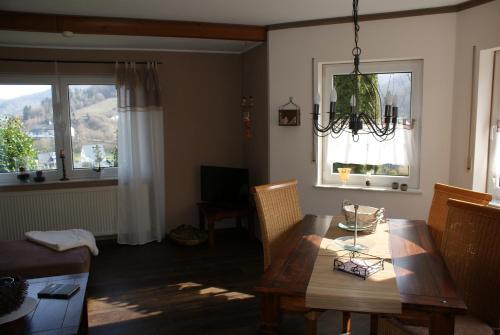 a living room with a dining room table and a chandelier at Ferienwohnung Klaus in Treis-Karden