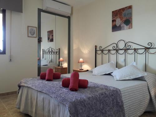 een slaapkamer met een bed met rode slippers erop bij ANDALUCIA 57 in Estepona