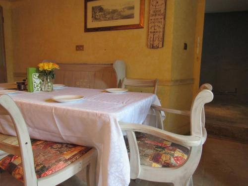 a dining room table with a white tablecloth and chairs at Les Deux Rives in Cierp