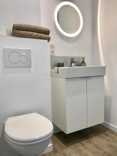 une salle de bain blanche avec des toilettes et un lavabo dans l'établissement Sleepinconcarneau, 200 m de la mer, centre-ville piétonnier, à Concarneau